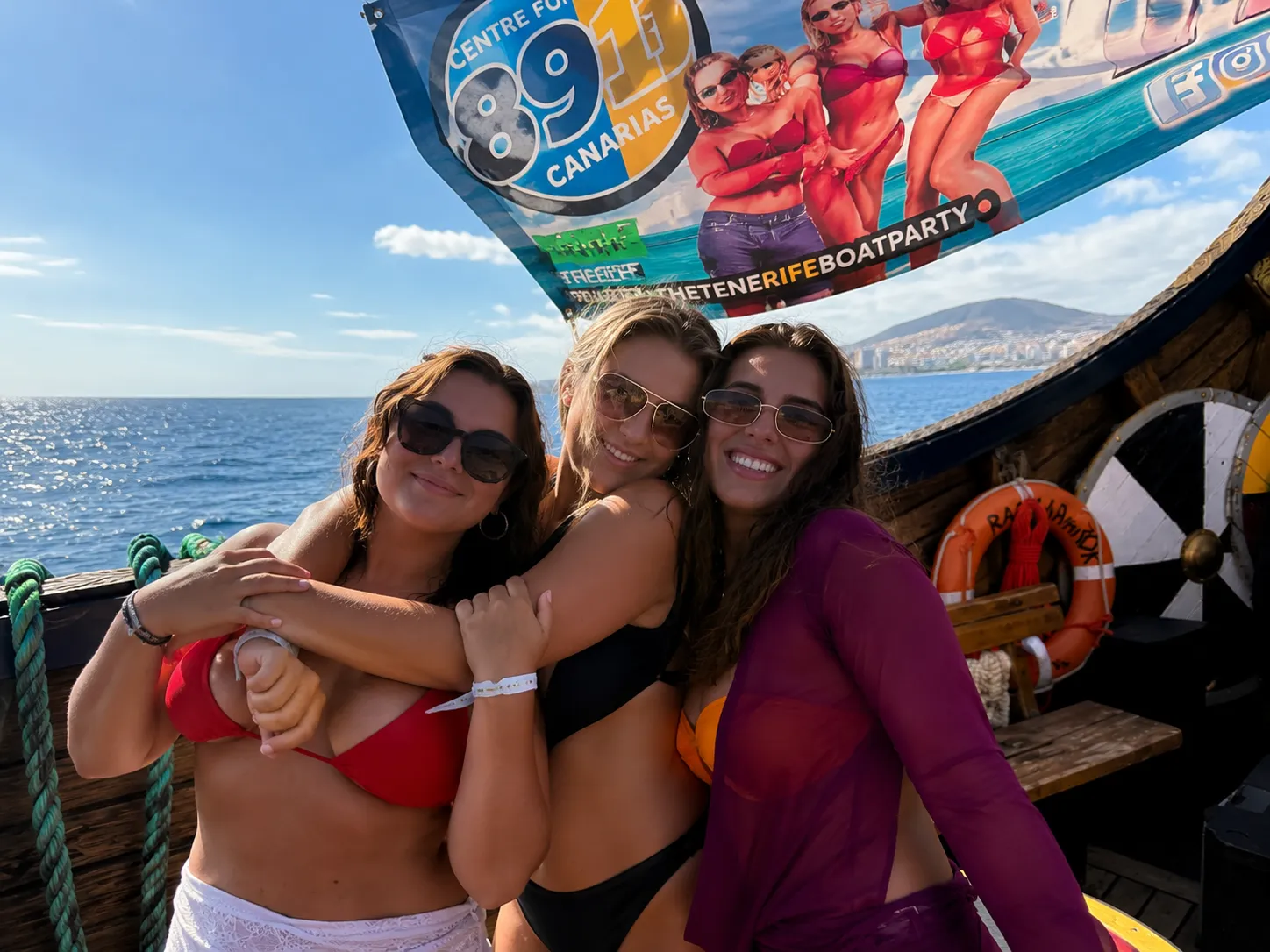 Three women smiling on boat deck in Tenerife waters