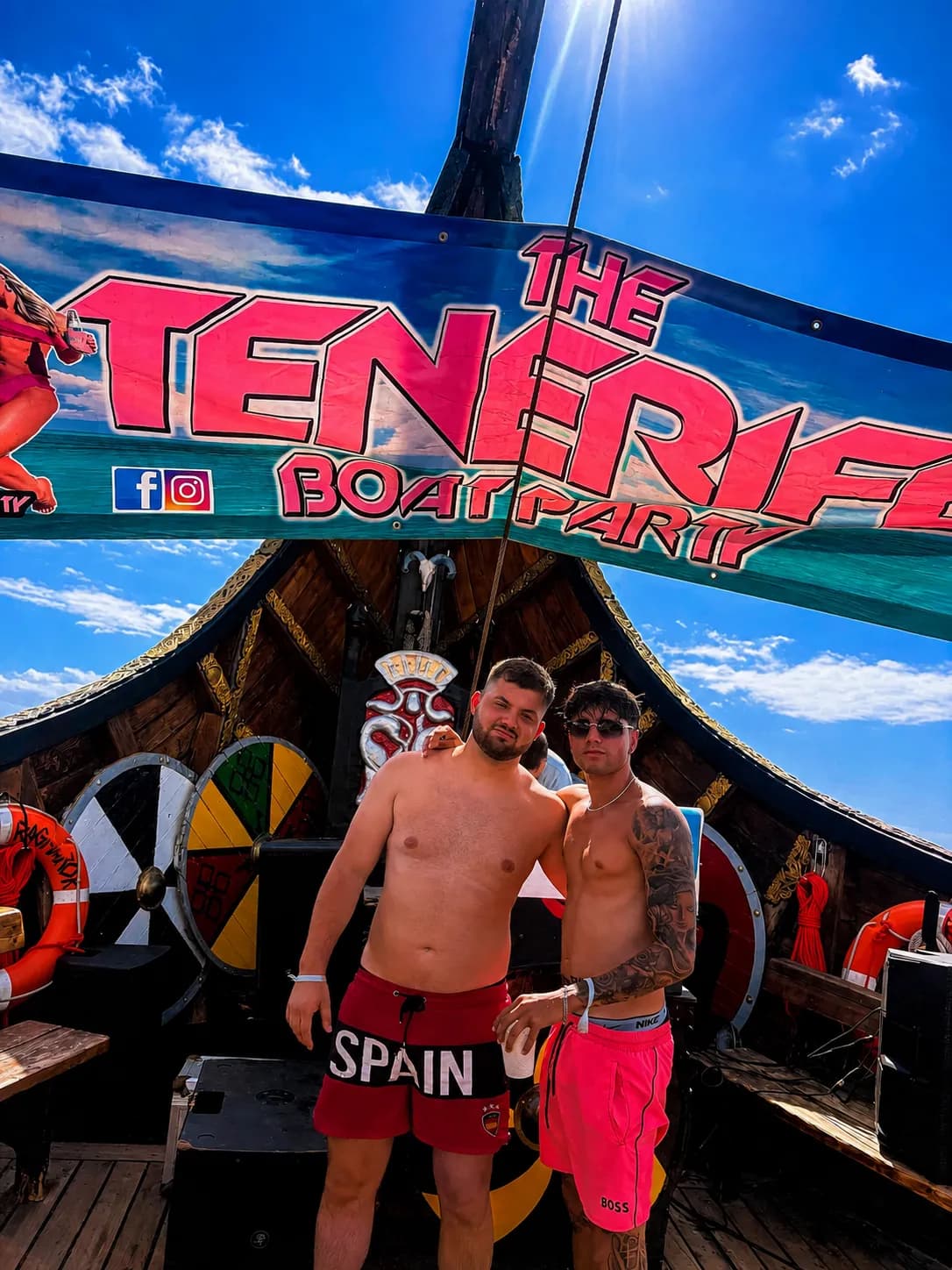 Two shirtless men posing at The Tenerife Boat Party vessel